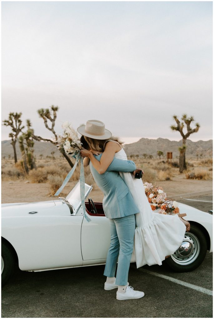 bride and groom hugging, bride and groom at joshua tree national park, vintage editorial photoshoot with car