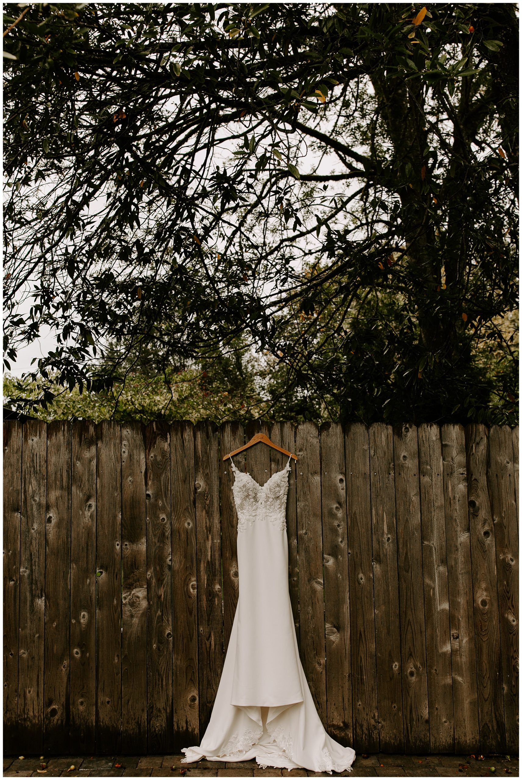 wedding dress hanging on fence