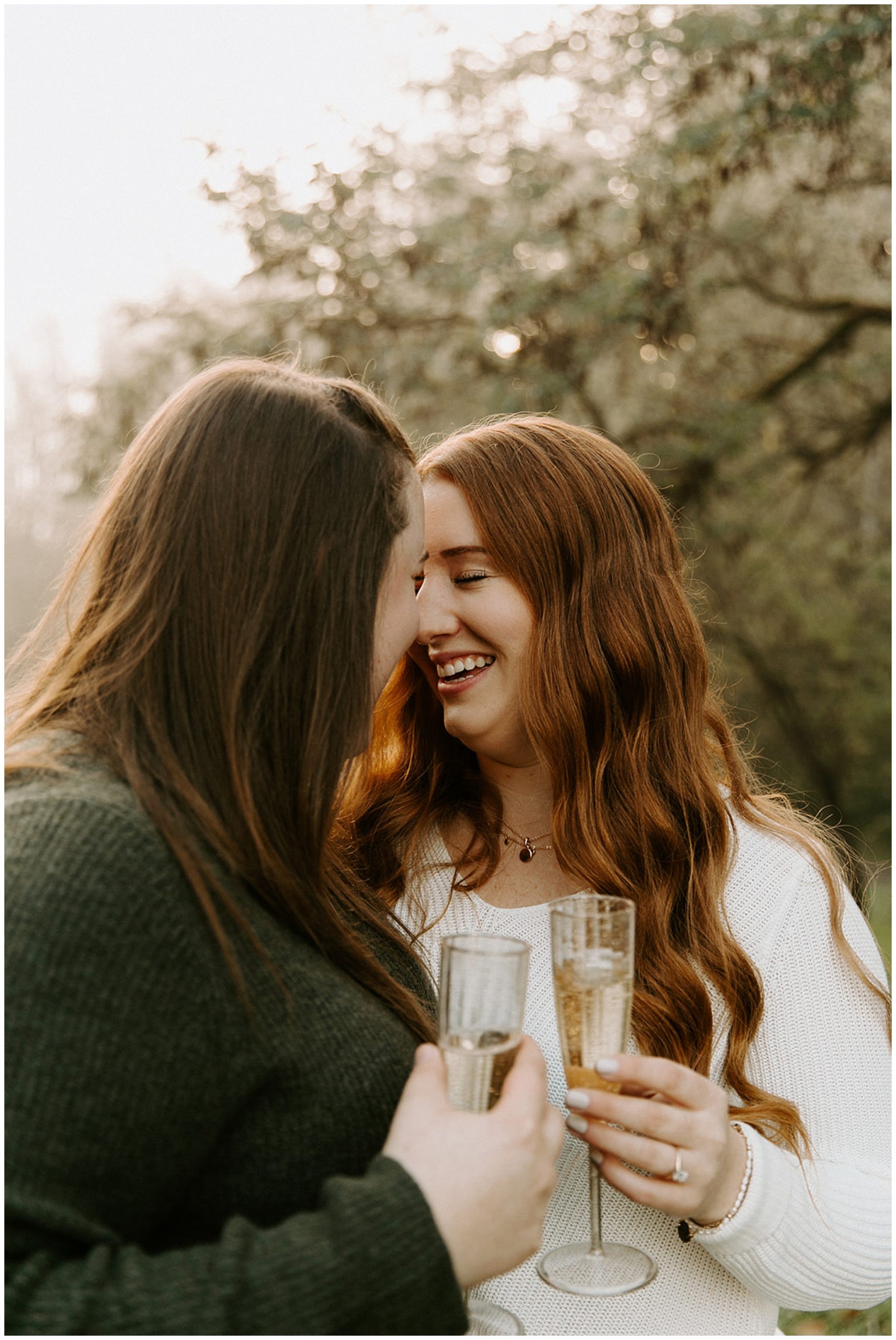 girls leaning foreheads together with champagne glasses