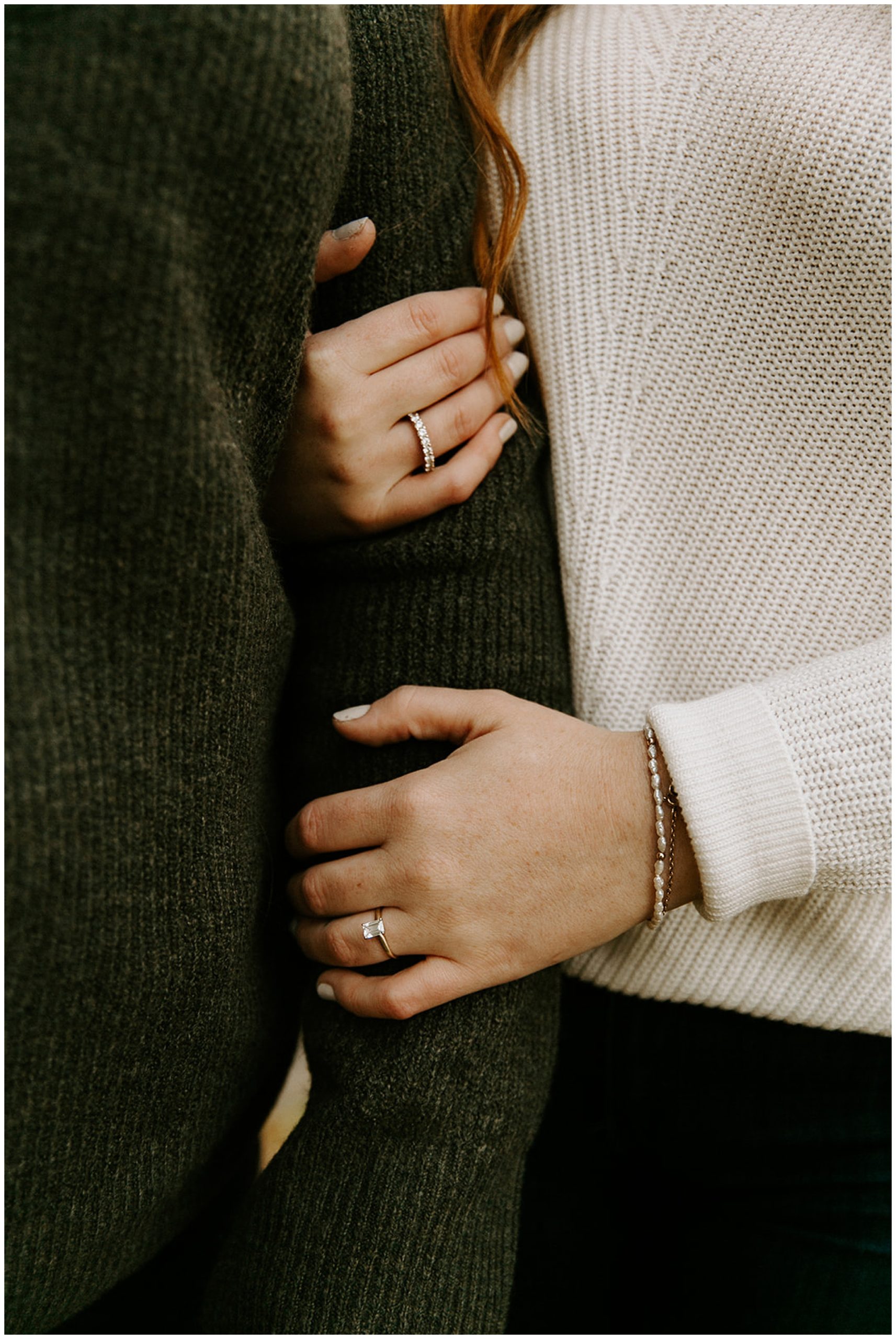 girl holding fiance's arm showing engagement ring