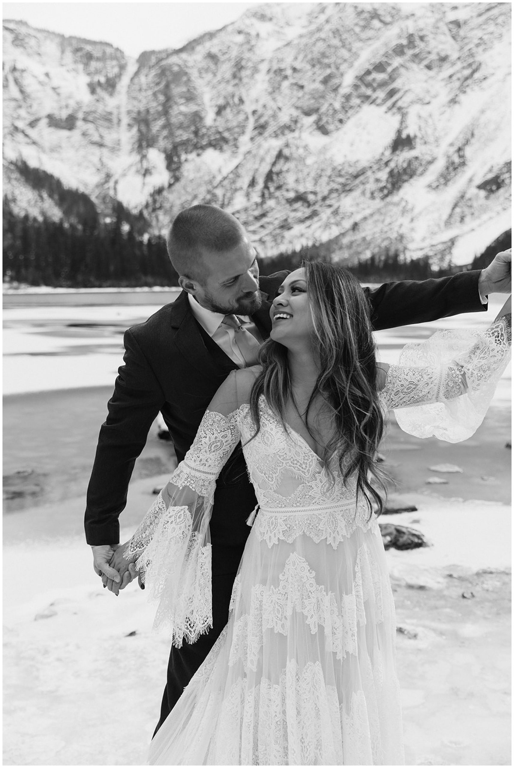 black and white photo of bride and groom on frozen lake