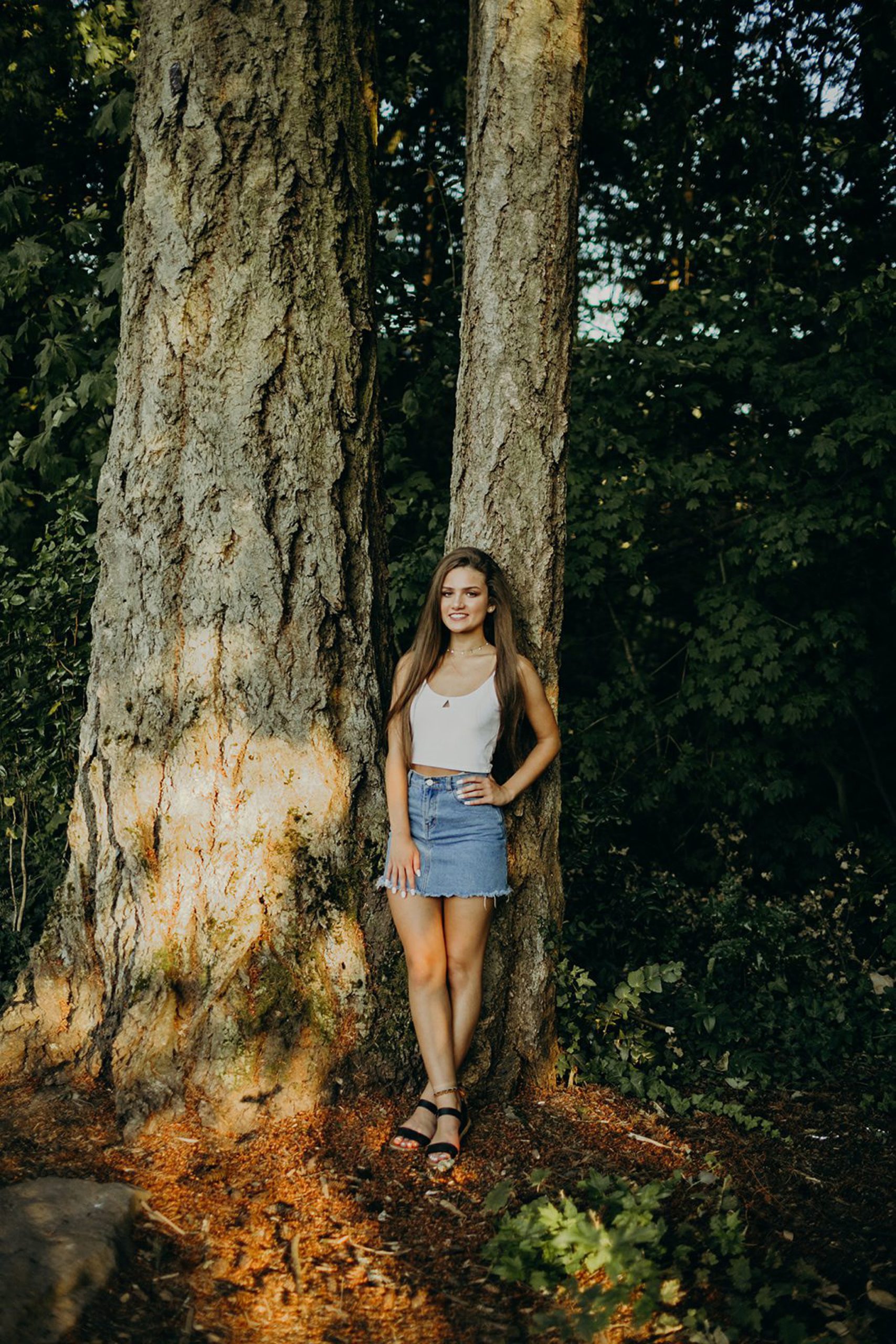 girl leaning against tree