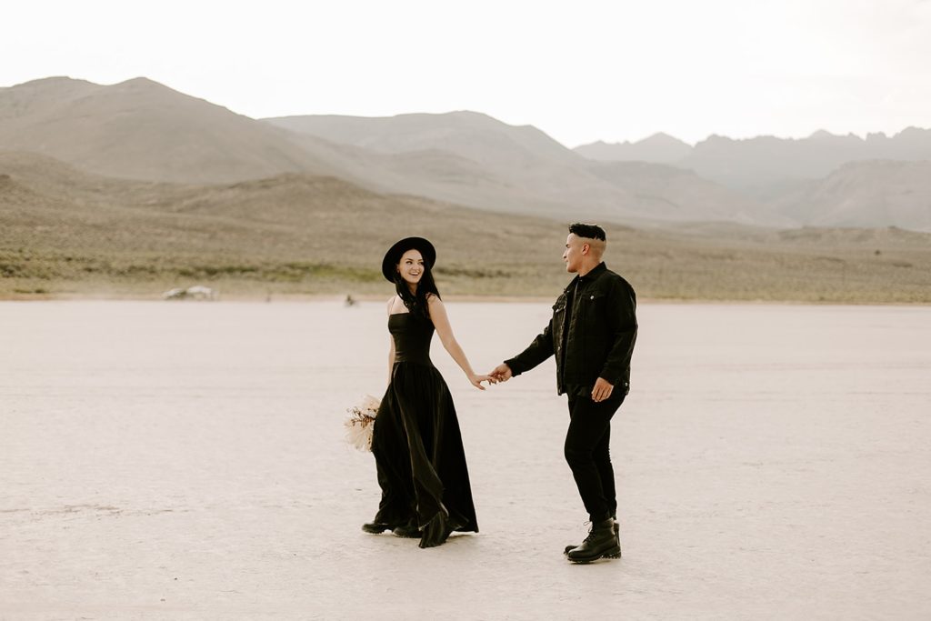 couple walking in desert wearing all black