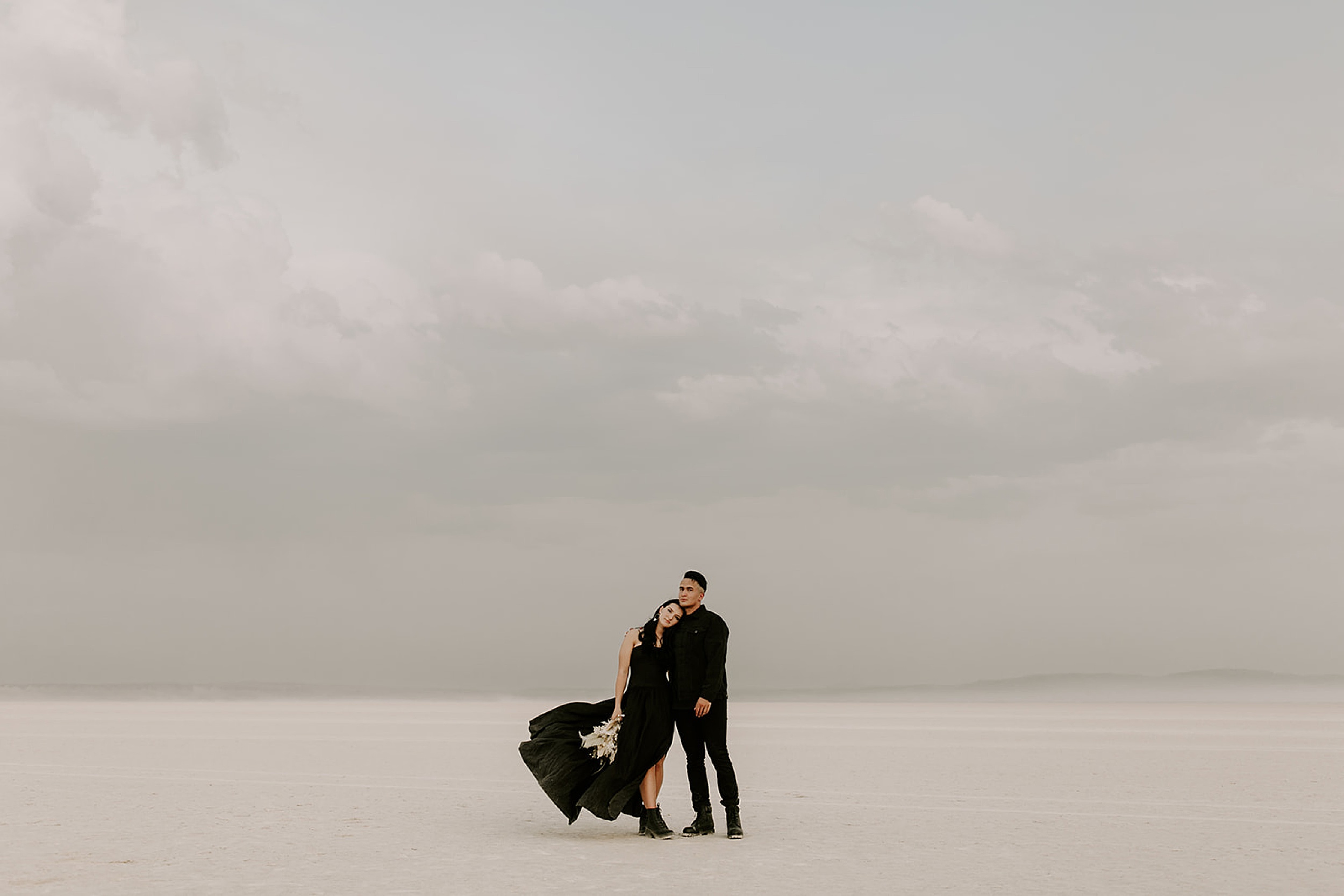 bride and groom standing in desert