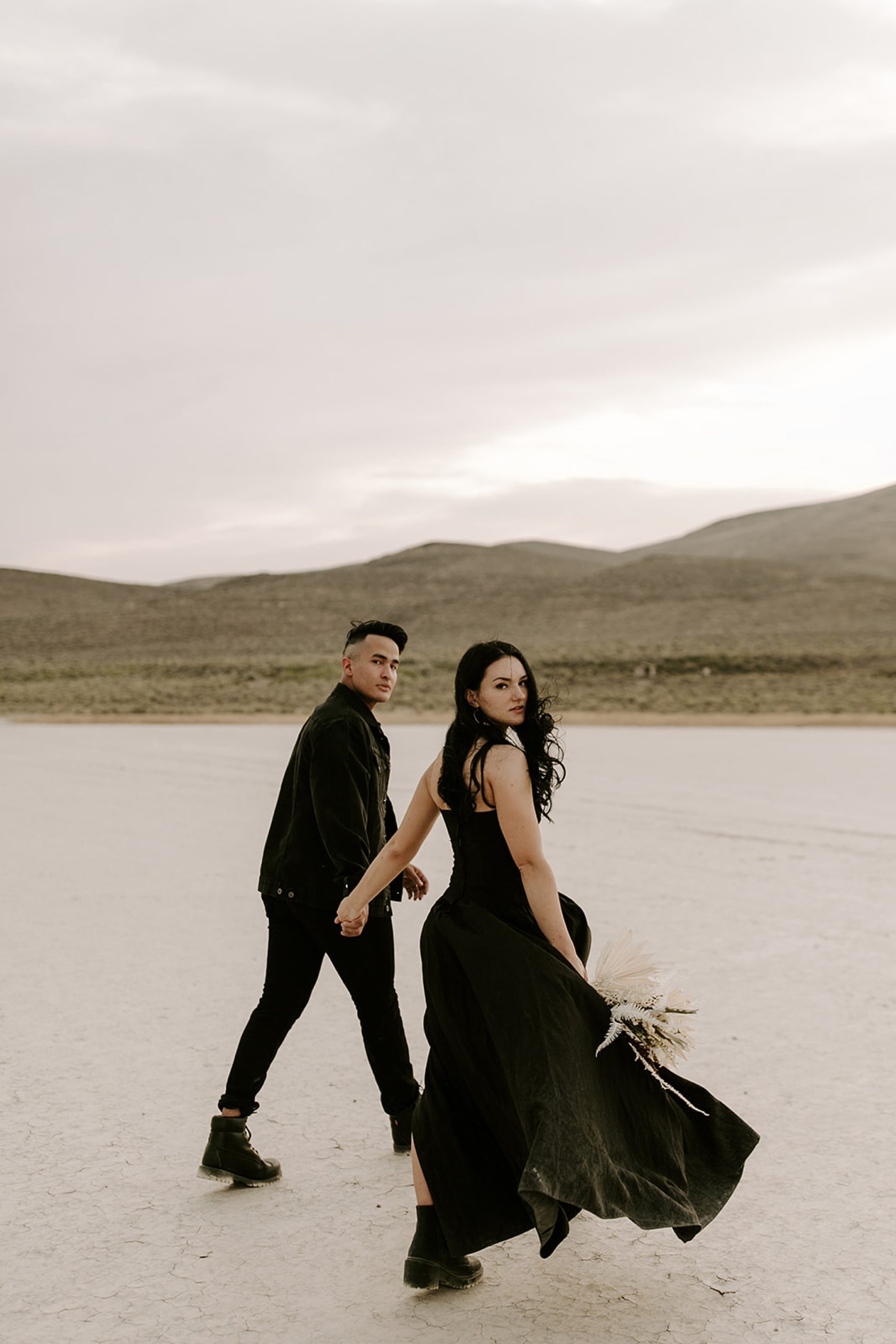 bride and groom walking in desert