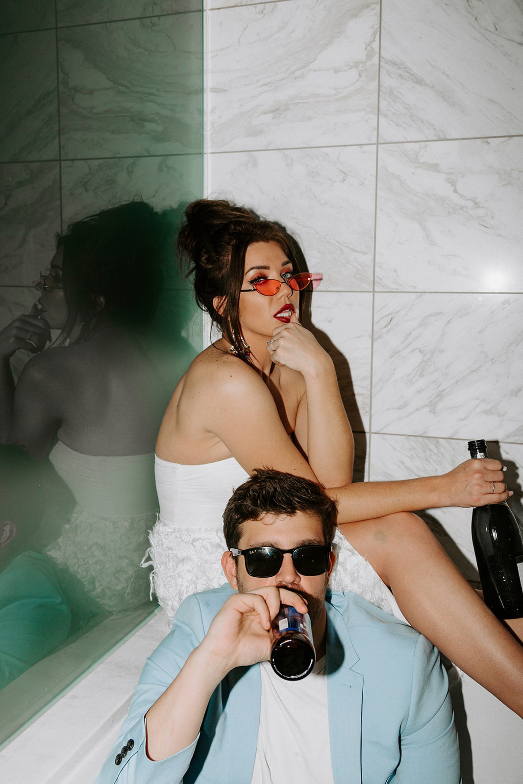 bride and groom sitting in bathtub and drinking