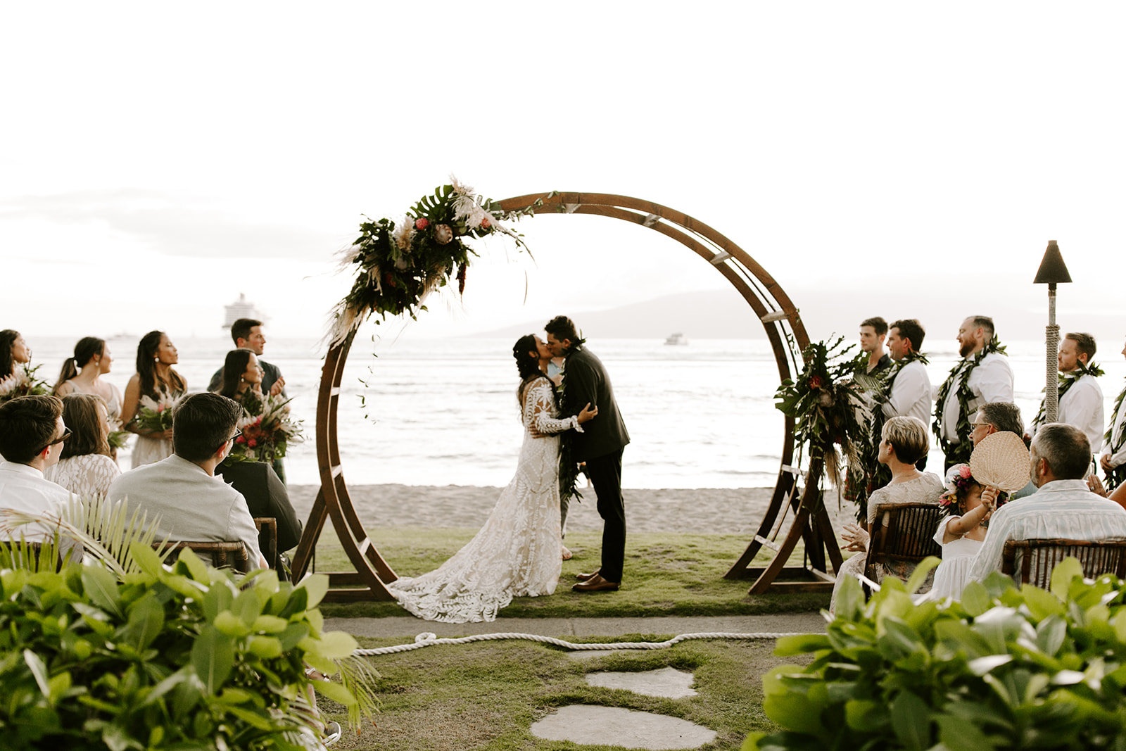 bride and groom kissing under arbor