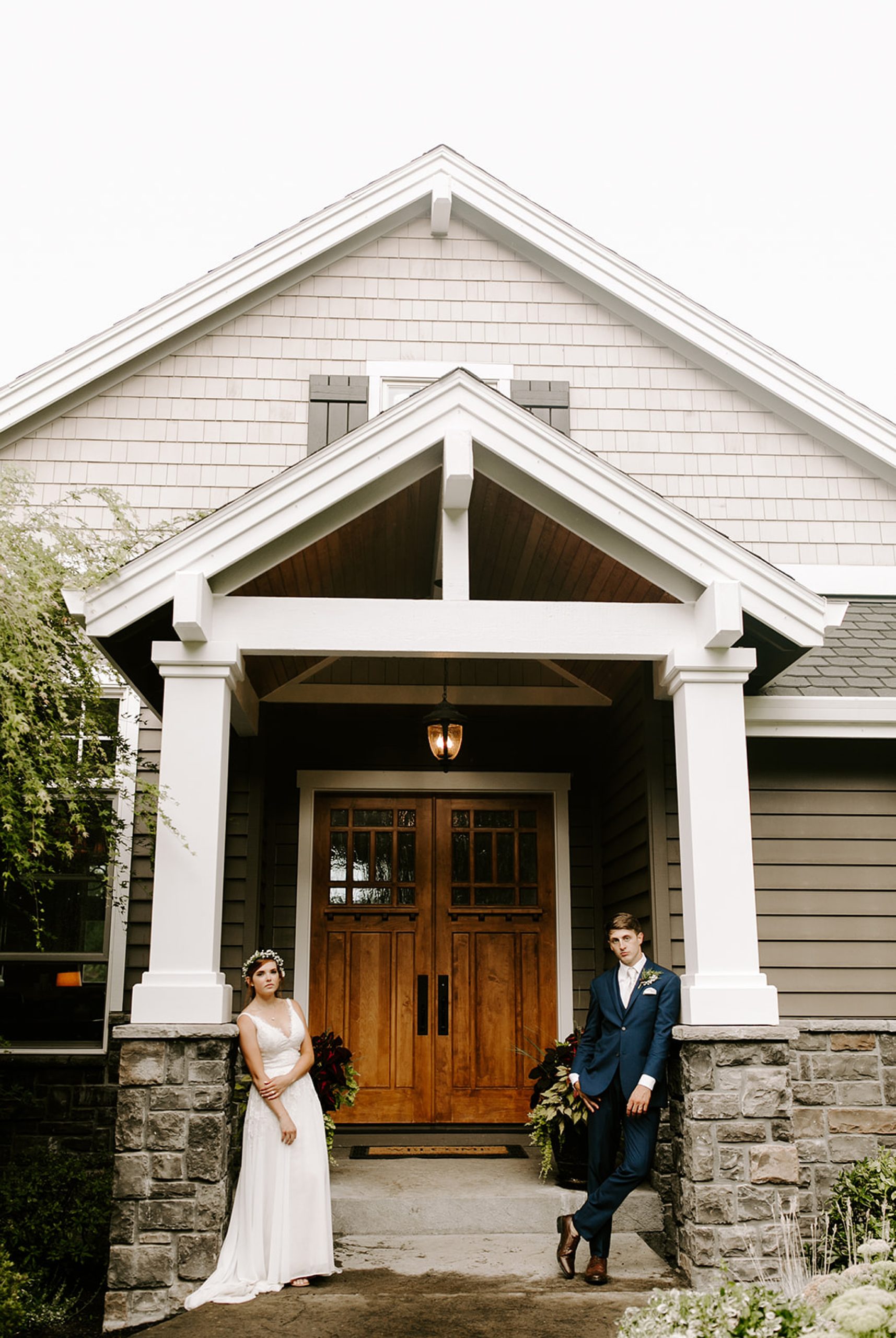bride and groom in front of house