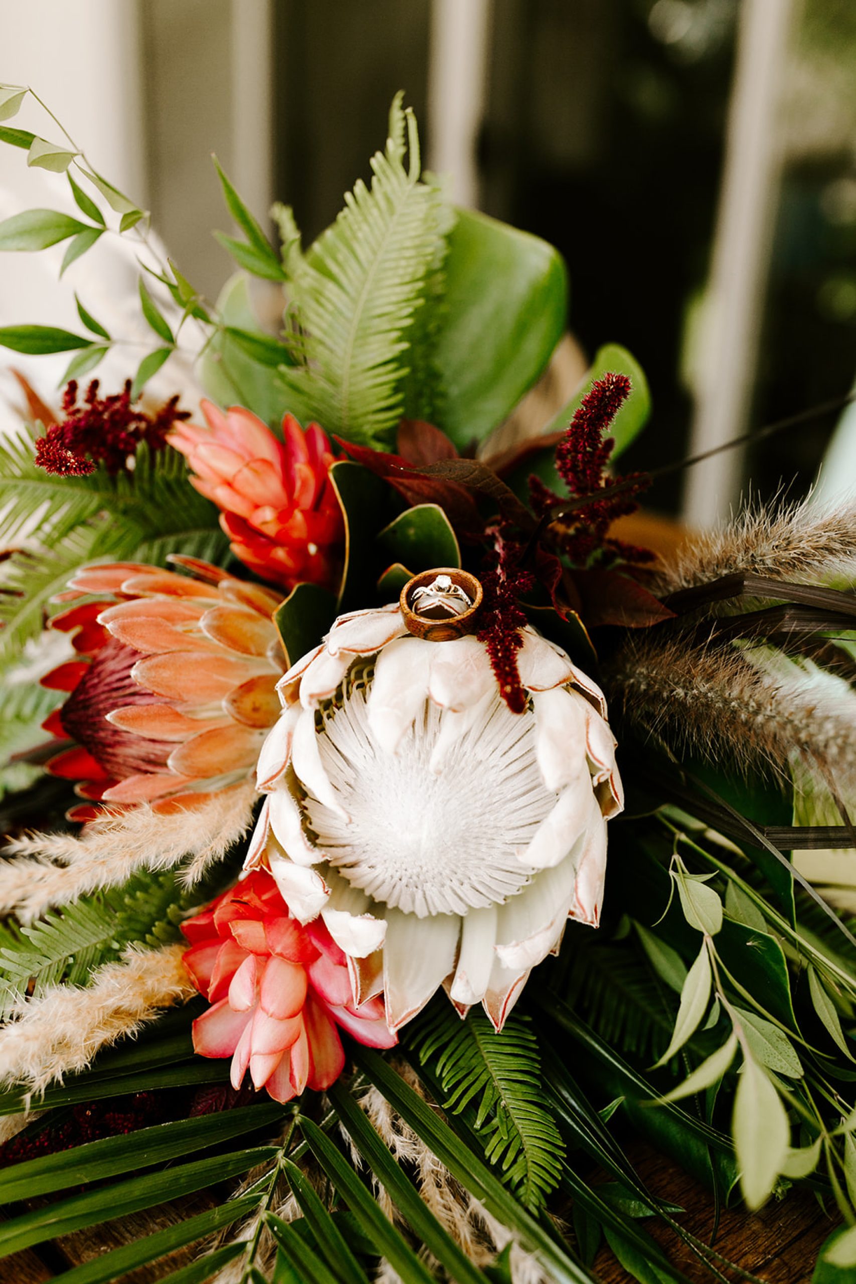 wedding rings sitting on tropical bouquet