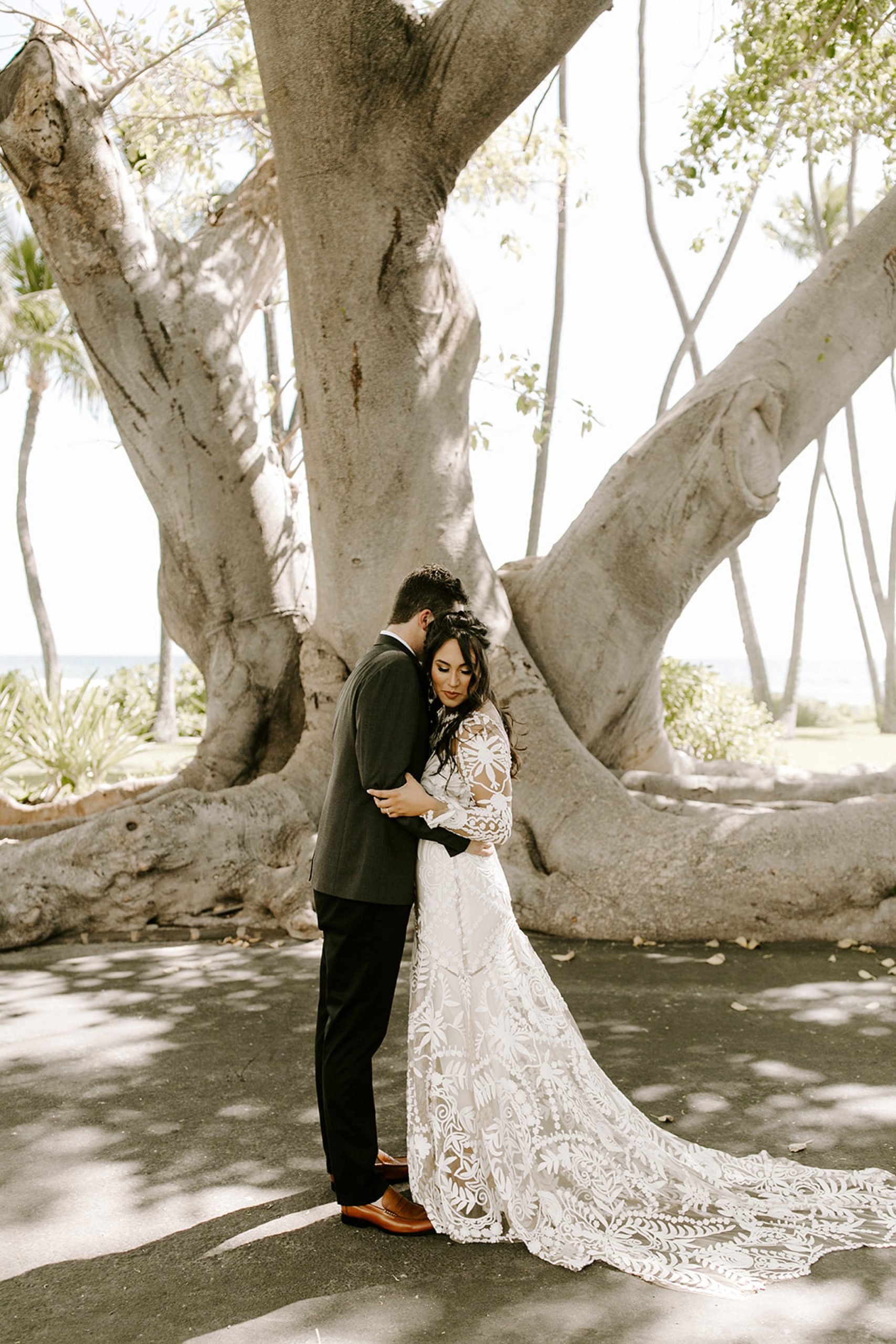 bride and groom hugging under tree