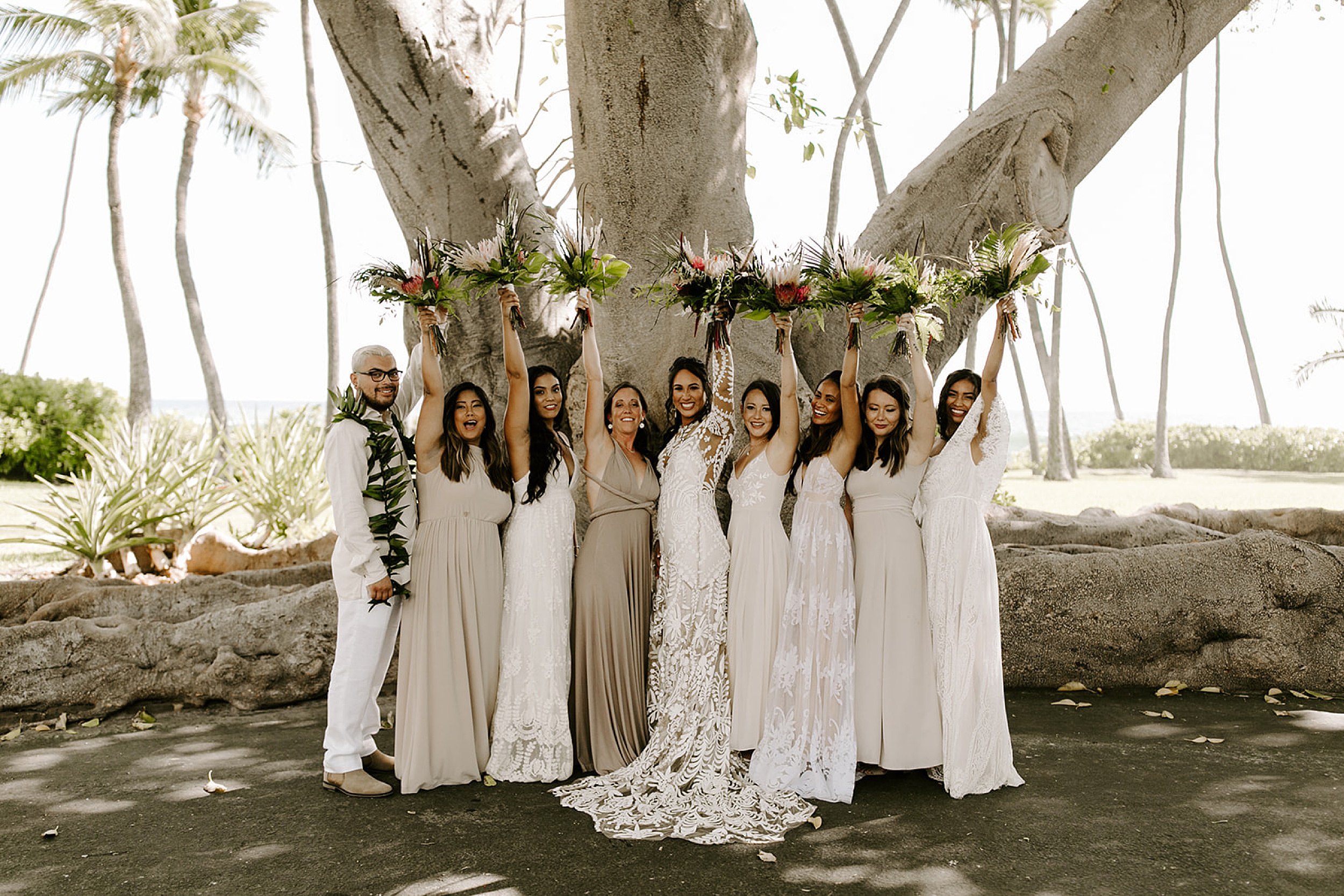 bridesmaids standing under tree
