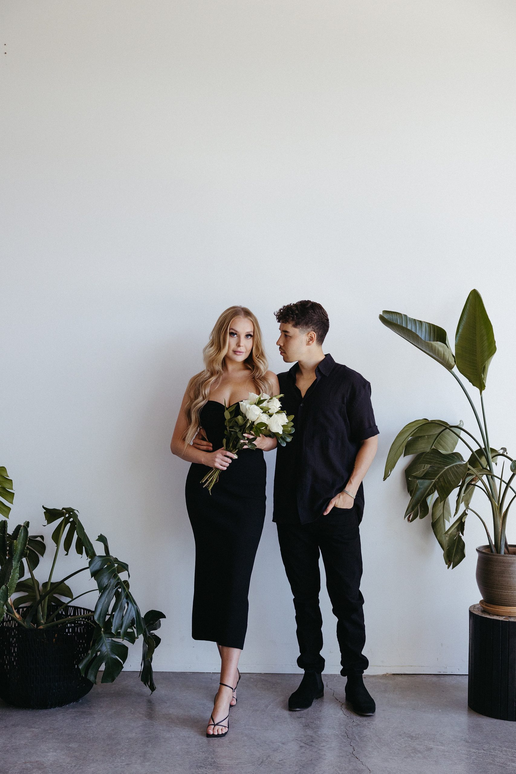 a woman with strawberry blonde hair and a man with black hair posing for their Portland engagement photos