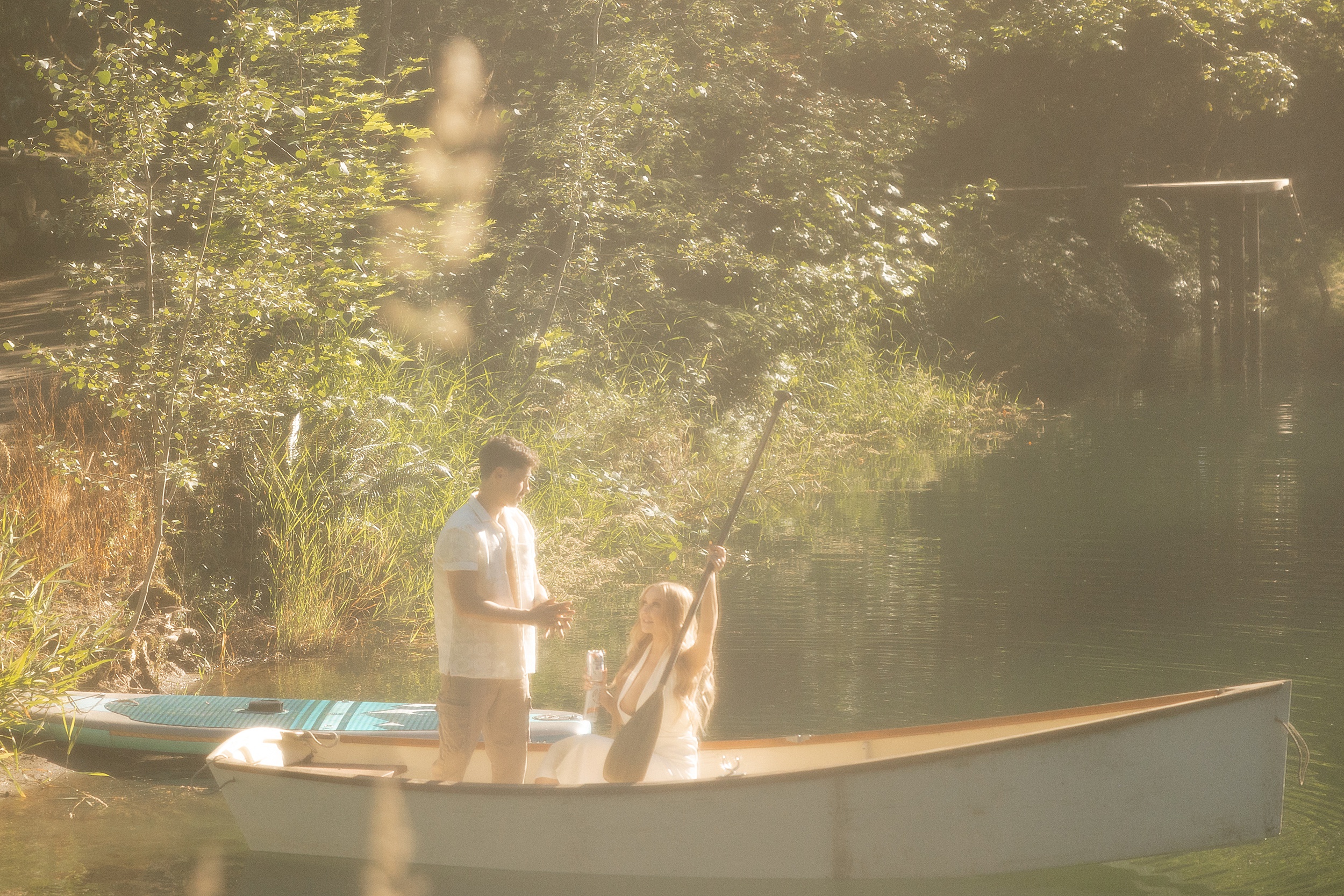 lake engagement photos with scenic greenery trees and a white small row boat