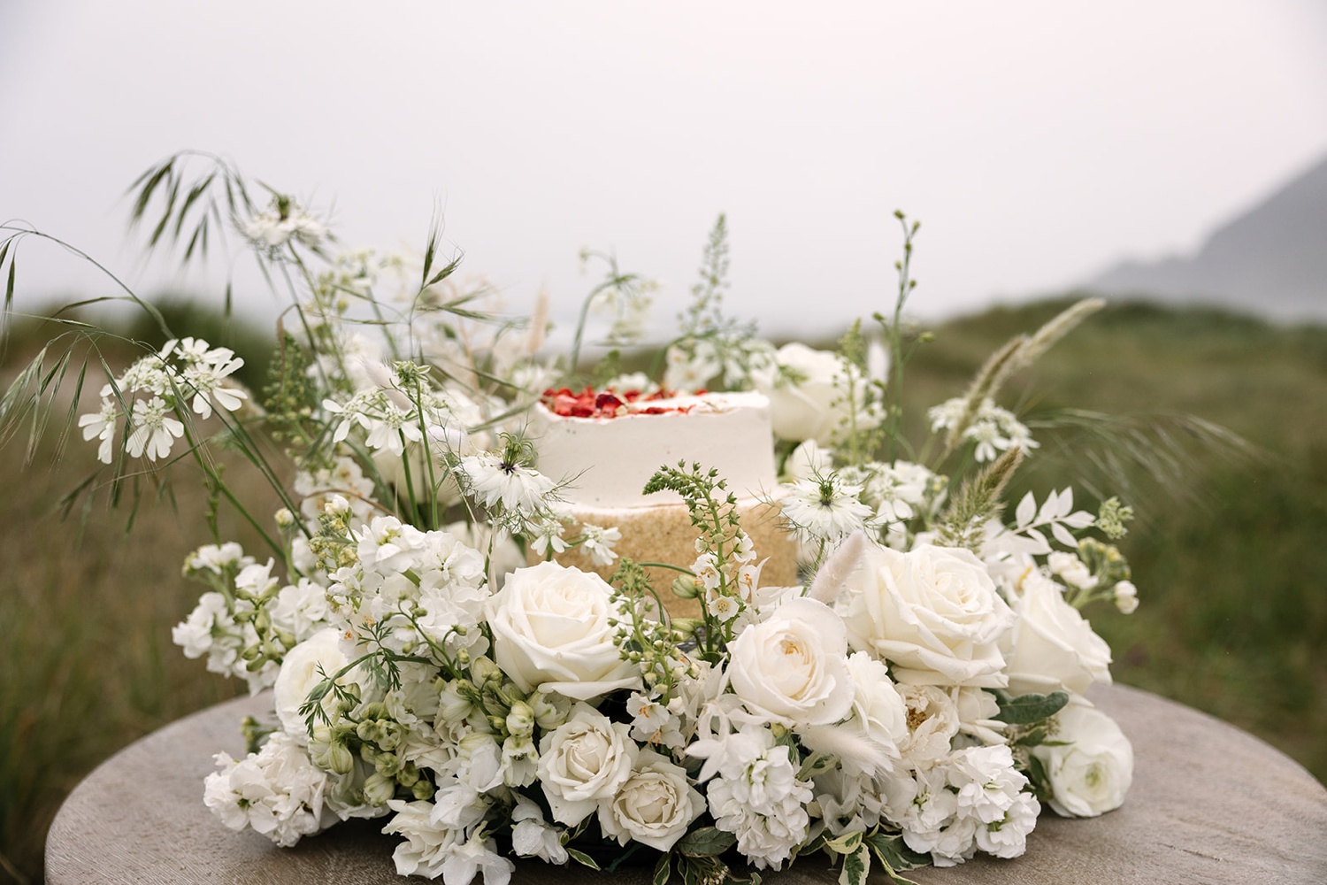 white roses and green florals on a white cake for an Oregon coast elopement
