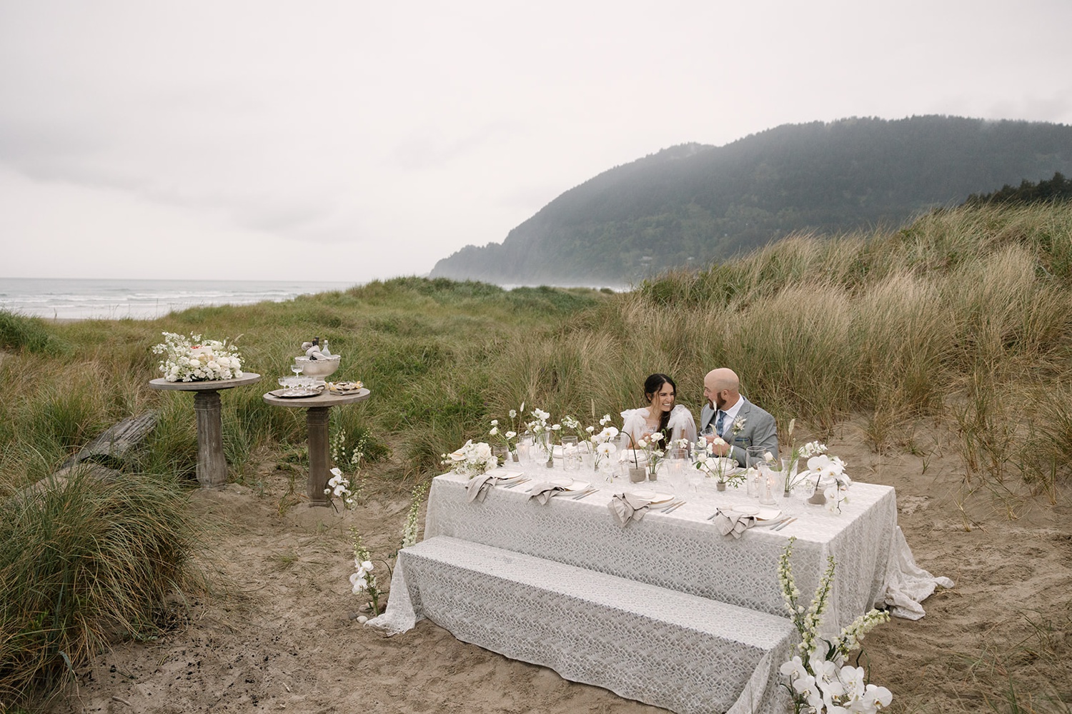 Bride and groom sitting at their reception table for their Oregon coast elopement