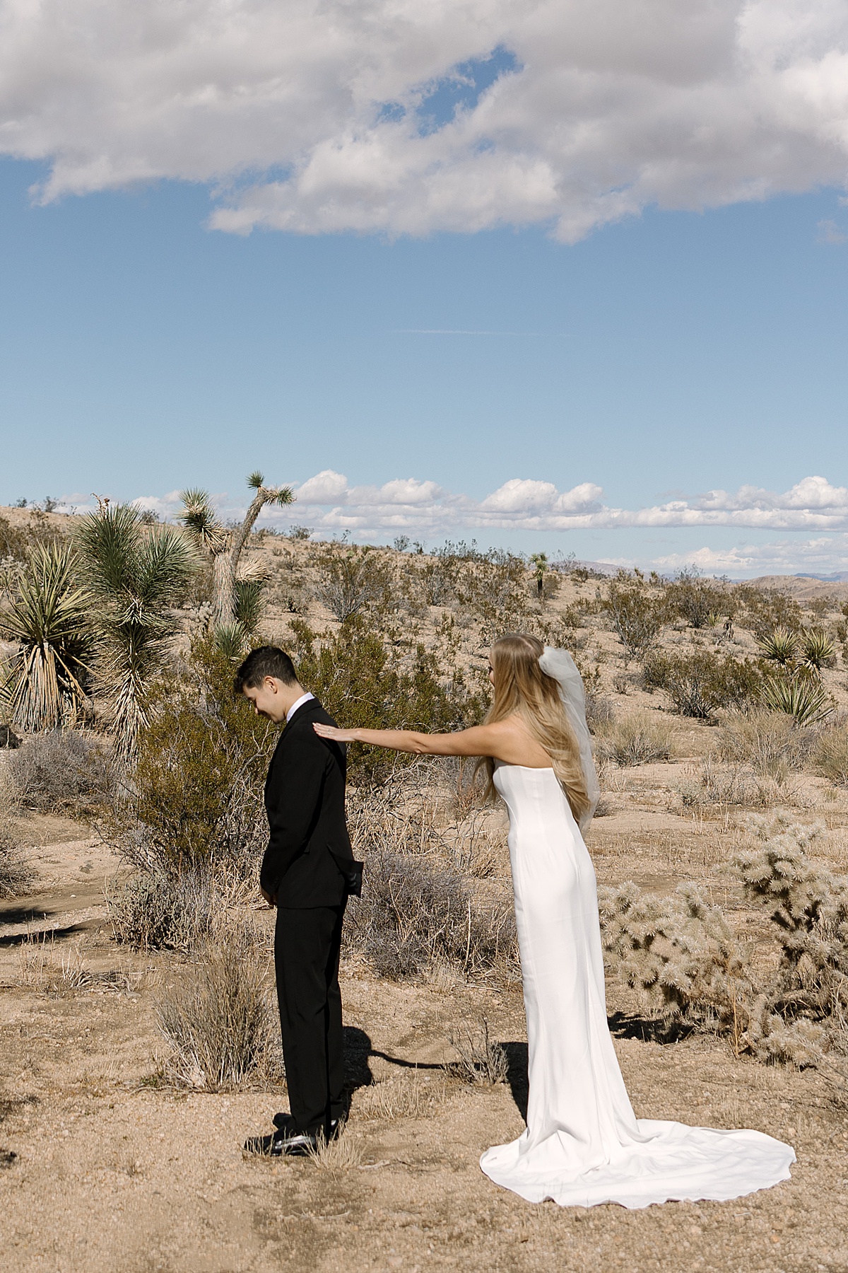 a bride in a white gown and groom in an all black suit at their Joshua Tree elopement