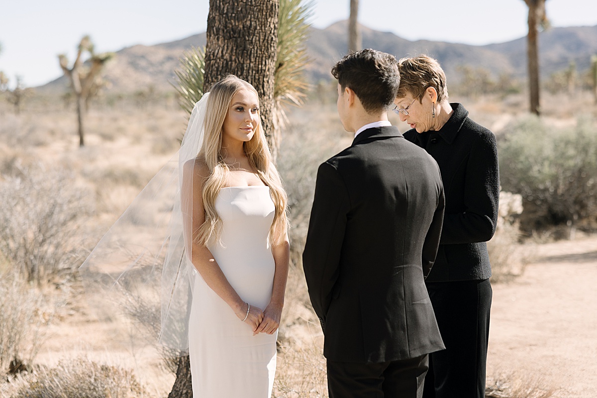 a bride in a white gown and groom in an all black suit at their Joshua Tree elopement