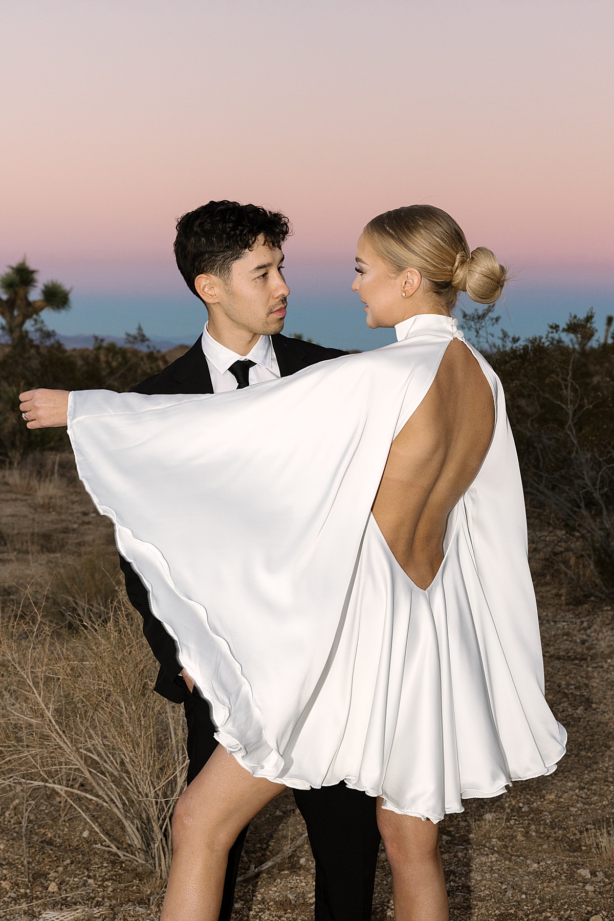 a bride in a white dress and groom in an all black suit at their Joshua Tree elopement
